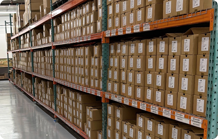 Warehouse shelves filled with labeled inventory boxes organized for storage, order processing, and fulfillment.